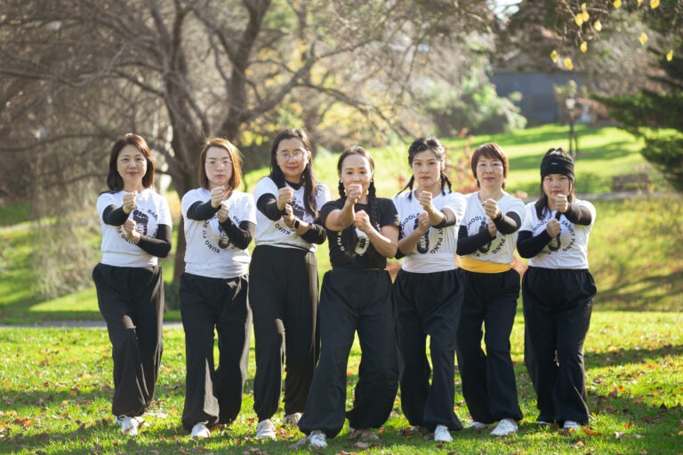 Anne Pang with her female kung fu students. Group pose in the gardens.
